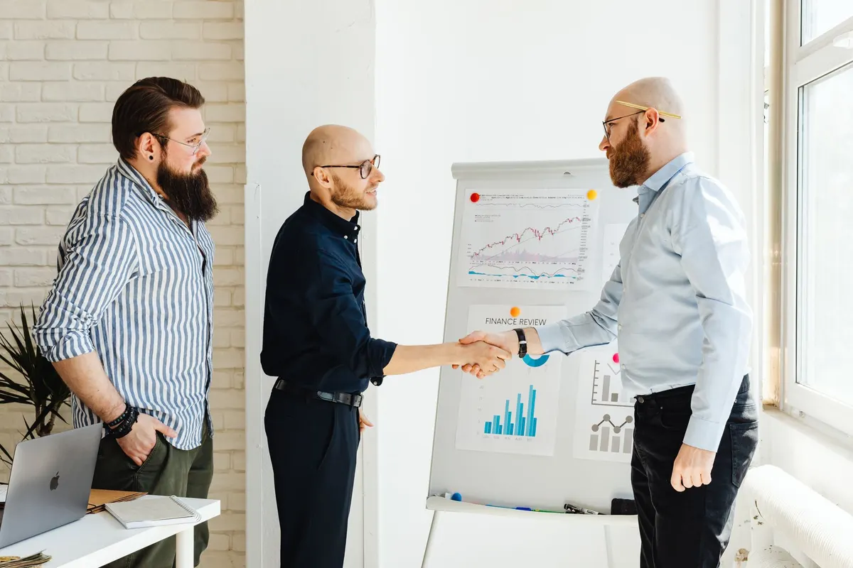 Three business colleagues engage in a productive meeting, exchanging ideas with data charts.